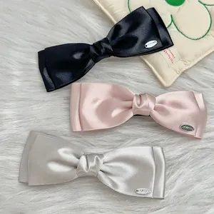 Three-piece set of satin double-layered bow hair clips in black, pink, and champagne silver