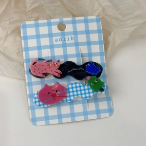 Détail de deux pinces à cheveux chat avec bases ondulées et décorations en acrylique