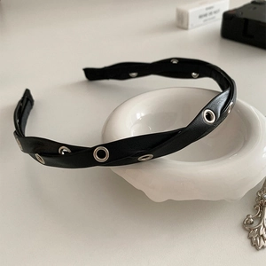 Detail of black braided PU leather headband featuring silver metal eyelet grommet accents