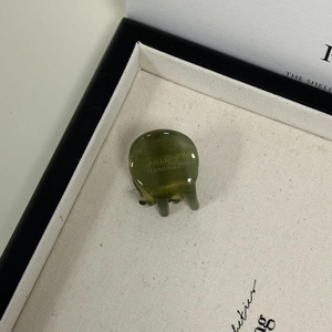 Close-up of olive green mini acetate hair clip with France Handmade gold lettering