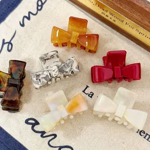 6-pack acetate bow hair clips in assorted colors on minimalist canvas background
