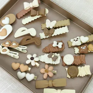Lot de barrettes à cheveux marron avec motifs papillons et ours sur un plateau