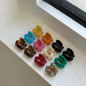 Set of 13 colorful cream-colored oval mini hair claws in various glossy acetate finishes