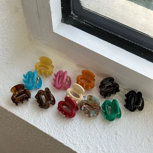Macro detail of twelve colorful mini resin hair claws with France Handmade engraving
