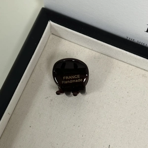 Detailed macro shot of dark brown acetate hair claw with gold France Handmade logo