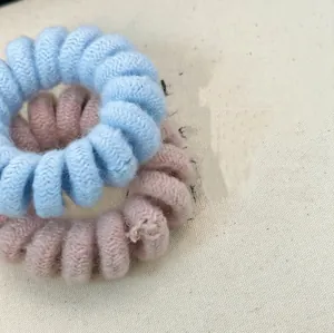 Knitted candy-colored telephone wire hair ties in light blue and soft pink styles