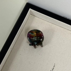 Detailed close-up of a marble acetate hair claw clip with a gold handmade logo stamp