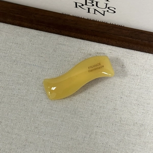 Détail de la pince à cheveux ondulée en acétate jaune faite main avec gravure