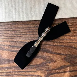 Elegant black velvet bow hair clip with metal alligator grip for a French style look