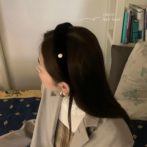Serre-tête vintage en velours noir avec accents en métal doré porté par un mannequin