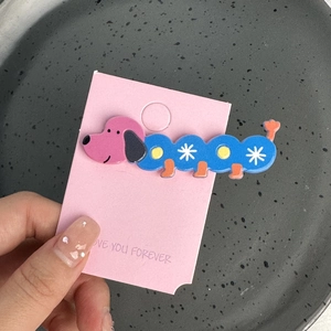 Détail de la pince à cheveux teckel avec motifs d'étoiles colorées sur carte
