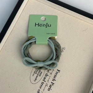 Detail of high-elasticity hair ties set with olive green bow and ribbon on a display card