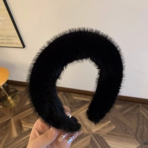 Close-up of a thick black faux fur headband showing soft plush texture and voluminous design