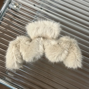 Detailed top view of large beige plush shark hair clip with soft faux fur texture