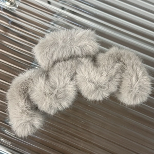 Close-up of thick grey plush hair claw showing soft faux fur texture and wavy design