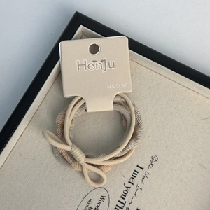 Detail of high-elasticity knitted hair bands in beige and khaki with bow on tray