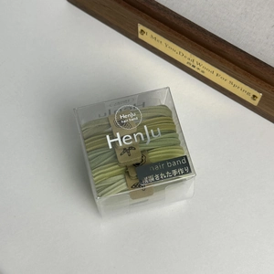 Detailed view of high-elasticity green hair ties set in a clear Morandi style plastic box