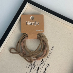 Close-up of high elasticity fabric hair ties in earthy tones with delicate bow detail