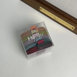 Five elastic hair bands in assorted colors inside a clear rectangular display box
