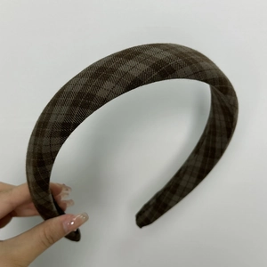 Detail of vintage dark plaid fabric headband with textured weave for hair styling