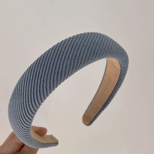 Detailed close-up showing the ribbed knit texture and padded design of the blue headband