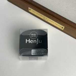 Close-up of black elastic hair bands neatly organized in a transparent brand box