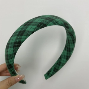 Detail of green and black plaid fabric headband with vintage British style texture