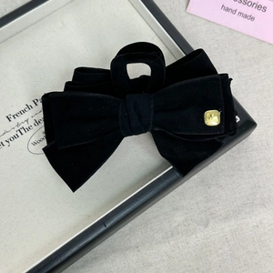 Macro shot of large black velvet bow hair claw with gold square metal hardware