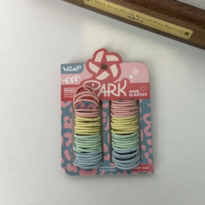 Macro shot of seamless baby hair ties in pastel pink, yellow, green, and blue colors