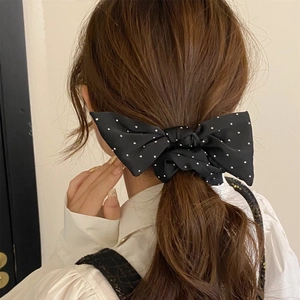 Elegant black satin bow scrunchie with white pearl dots for women's low ponytail style