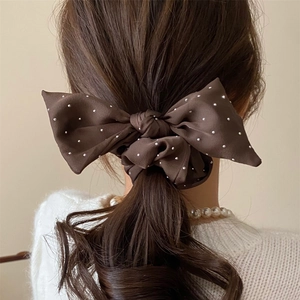 Elegant dark brown bow hair tie with white polka dots on a satin ponytail holder