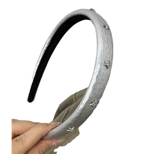 Silver star-studded padded headband with shiny metallic finish and sparkling rhinestones
