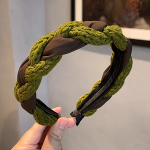 Close-up of green knit and brown satin braided headband with retro texture