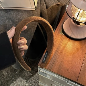 Détail d'un serre-tête en laine marron avec étiquette faite main pour l'automne