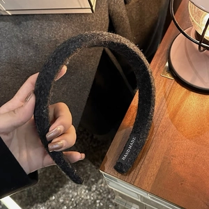 Vue détaillée du bandeau en laine gris foncé avec étiquette noire faite à la main