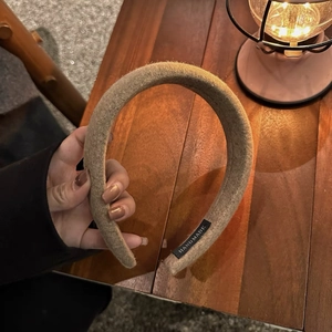 Détail d'un serre-tête en laine kaki avec une étiquette tissée HANDMADE très élégante