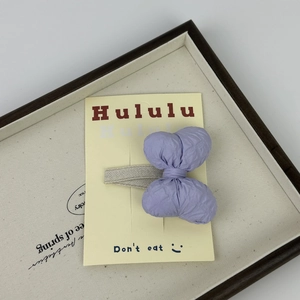 Dettaglio della macro texture del fiocco per capelli in tessuto viola su carta