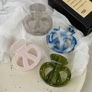 Elegante Haarspangen aus Acetat in Brezelform in vier Farben mit feinen Metallnieten