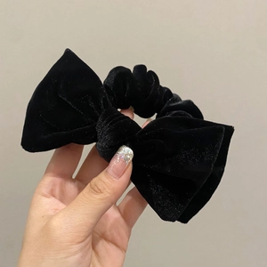 Elegant black velvet bow scrunchie with a vintage French style for women hair styling