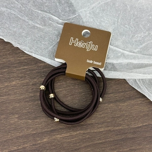 Détail du lot de 5 élastiques à cheveux marron avec perles dorées sur support