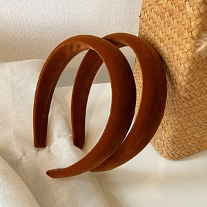 Detail of two padded velvet headbands in pumpkin brown color for elegant autumn styling
