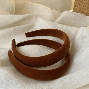 Brown velvet padded headband in retro style on white linen background for women