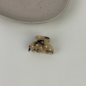 Vista dettagliata della molletta in acetato con strass scintillanti e incisione fatta a mano