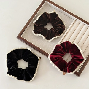 Three velvet scrunchies with faux pearl edges in burgundy, brown and black colors