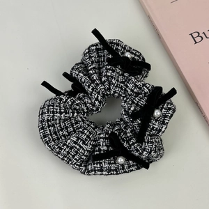 Chouchou vintage en tweed pied-de-poule avec nœuds en velours et perles sur livre rose