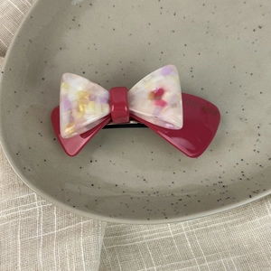 French vintage double-layered acetate floral bow hair clip on a ceramic tray