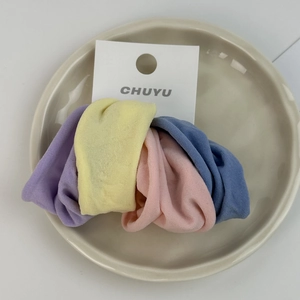Detail of four colorful soft elastic hair bands on a ceramic tray with display card