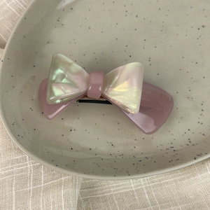 Macro view of a 3D double-layered acetate bow hair clip with a pearlescent finish