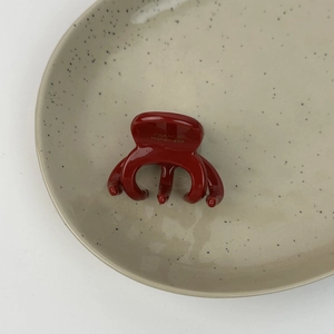 Vue détaillée d'une pince à cheveux rouge foncé avec logo France Handmade doré