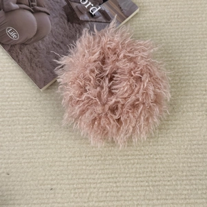 Détail d'un chouchou en peluche rose avec texture douce en fausse fourrure sur tapis